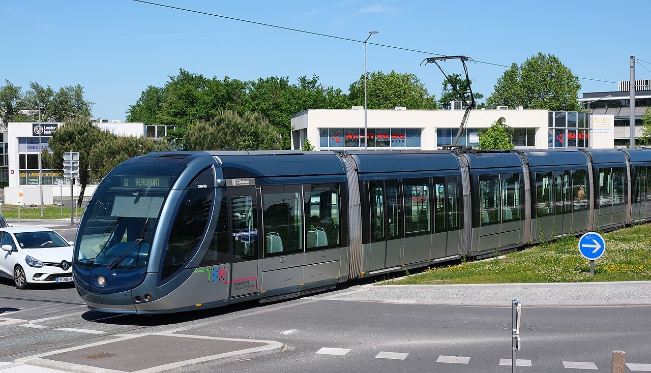 A tram on a grassed track outside the center