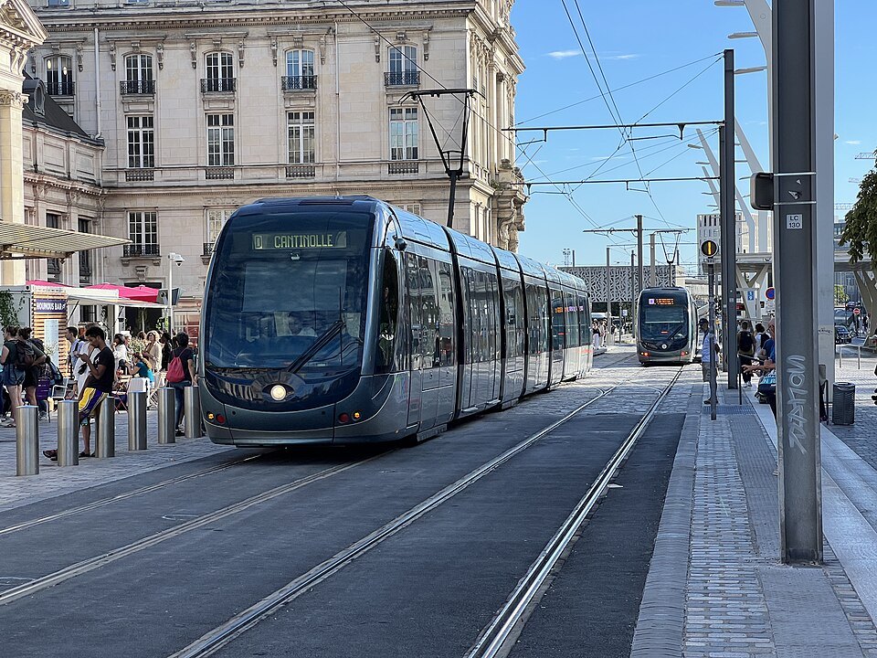 A line D tram at a stop by the Parvis