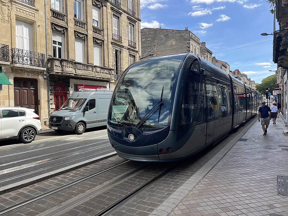 A line D tram in a street of stone houses